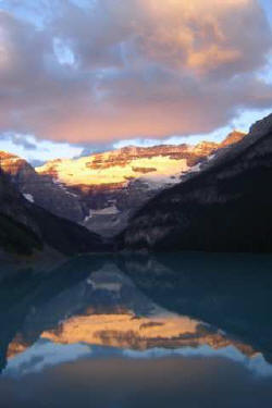 The amazing reflective quality of Lake Louise lies in the fine silty glacial materials suspended in the water. These produce a mirror-like reflection, especially in the early morning before the breezes begin rippling the waters of Lake Louise. The most dramatic sunrise pictures occur between 4:30 a.m. and 6 a.m. in July. The drama begins well BEFORE the sun comes up!